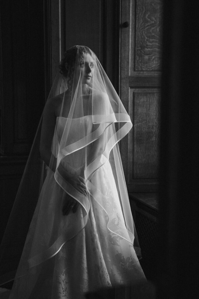 A black and white photograph of a bride in her wedding dress
